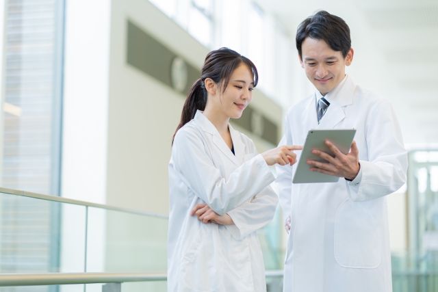 タブレットを見て会話する医者たち